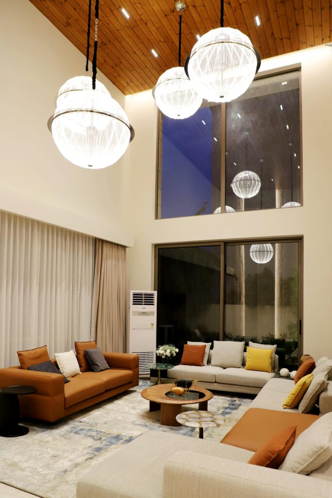 Spacious living room featuring modern decor, elegant lighting, and ceiling-to-floor windows.
